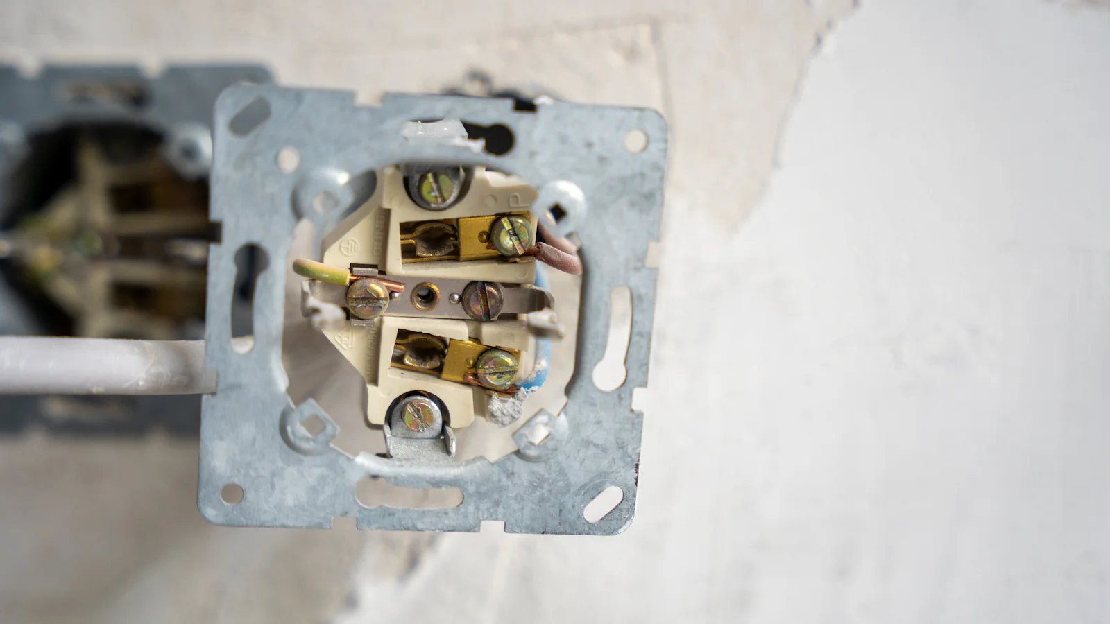 Wall socket opened up to show its wiring
